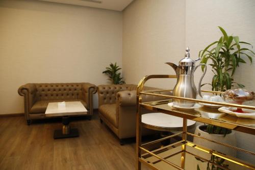 a waiting room with a couch and a table and chairs at MADEN Al Rawda مادن الروضة in Al Madinah