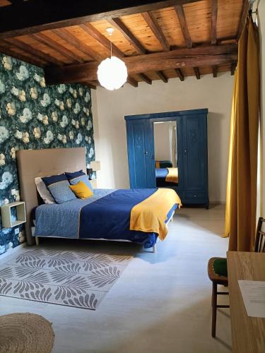 - une chambre avec un lit bleu et jaune dans l'établissement La salamandre de l'escat, à Montastruc-de-Salies