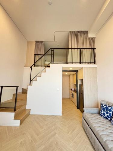 a living room with a staircase and a couch at Cassia Rama9 Loft Highrise View Central in Bangkok
