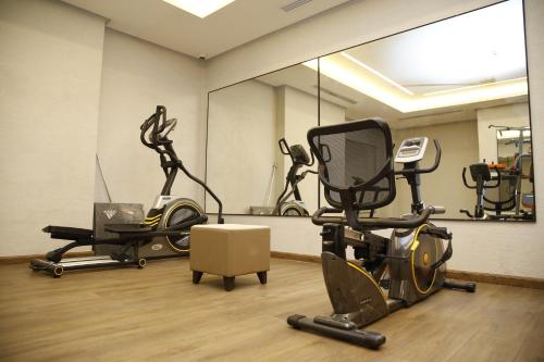 a gym with two exercise bikes and a mirror at MADEN Al Rawda مادن الروضة in Al Madinah