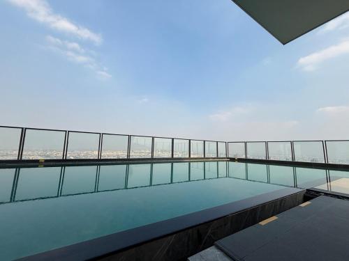 a balcony with a swimming pool on top of a building at Cassia Rama9 Loft Highrise View Central in Bangkok