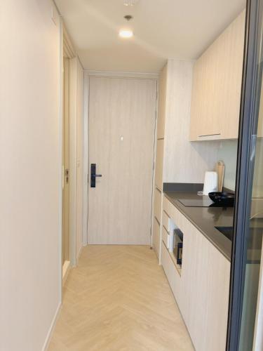 a hallway of a kitchen with a door in it at Cassia Rama9 Loft Highrise View Central in Bangkok