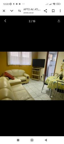 un salon avec un canapé et une table dans l'établissement Edifício Jorge amado, à Guarapari