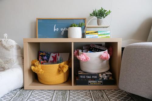 a book shelf with baskets and books in a living room at Walk to Highland Square, Sleeps 8 in Akron