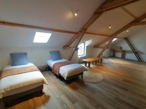 - une chambre mansardée avec 2 lits et une table dans l'établissement Charmante maison, à Ardentes