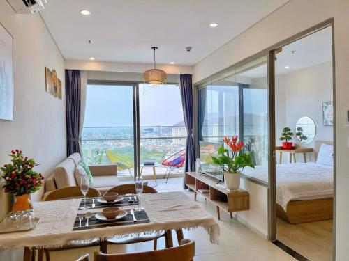 a bedroom with a bed and a dining room with a view at The Sóng Vũng tàu -Thuỷ còi in Vung Tau