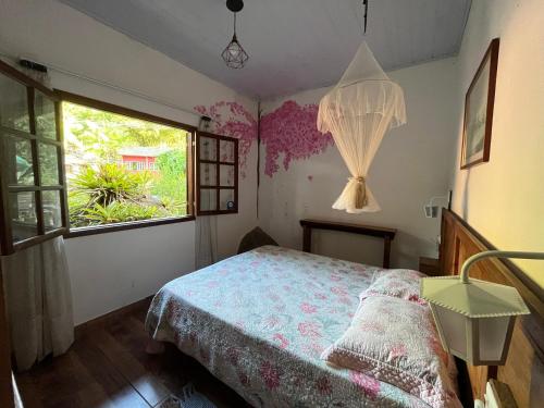 a bedroom with a bed and a window at Chácara portal do dragão casa completa para 6 pax in Paraty