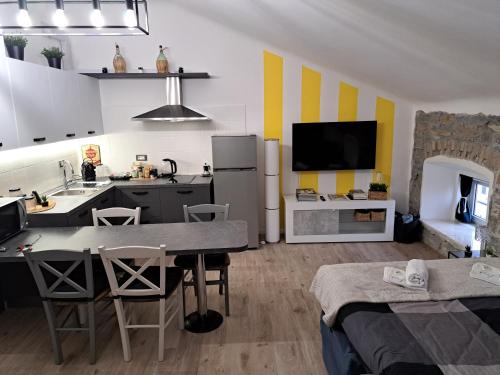 una cucina e un soggiorno con tavolo e TV di The way to trieste bikes storage a Trieste