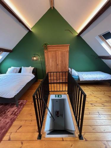 a bedroom with two beds and a green wall at Vakantiewoning Huis 14 in Mechelen