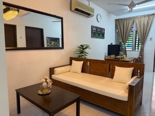 a room with a bed and a table and a mirror at Barakah Homestay Taman Belimbing in Jitra