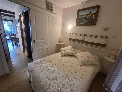 - une chambre avec un lit et un couloir avec une table dans l'établissement Appartement à proximité de la plage, à Saintes-Maries-de-la-Mer