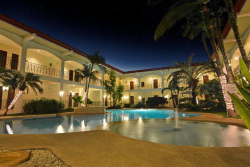 a large building with a swimming pool at night at Citystate Asturias Hotel Palawan in Puerto Princesa City