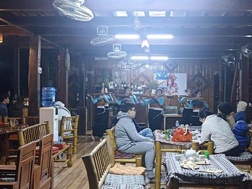 a group of people sitting at tables in a restaurant at Thao Ly Homestay Mai Chau in Hòa Bình