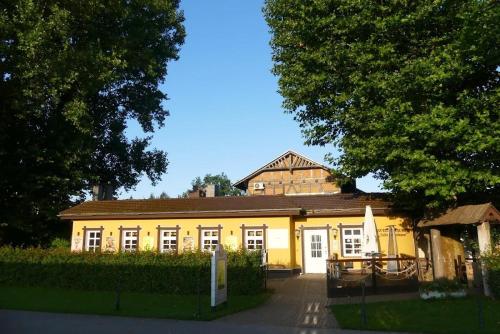 a large yellow building with a roof at Havelpension in Rathenow