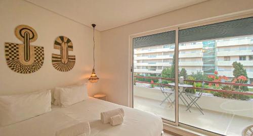 a bedroom with a white bed and a large window at YES! Incrível Vista Piscina T2 HsR Vilamarina in Vilamoura