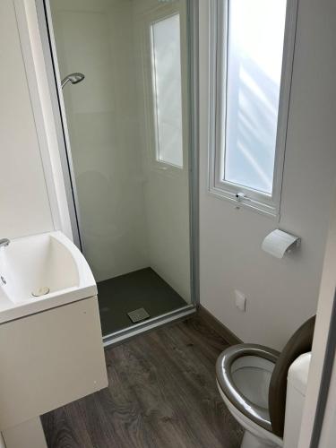une salle de bain avec toilettes, lavabo et fenêtre dans l'établissement Azur 77, à Fréjus