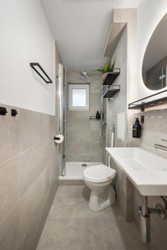 a bathroom with a toilet and a sink and a shower at LudwigsCozyEscape - Ruhiges Design-Apartment mit Balkon & Parkplatz, 4 Gäste, SmartTV in jedem Zimmer, Highspeed WLAN, Workspace, 24h Self Check-in in Ludwigsburg