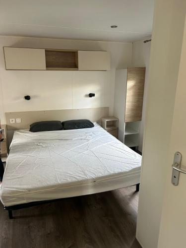 une chambre avec un lit blanc dans une pièce dans l'établissement Azur 77, à Fréjus