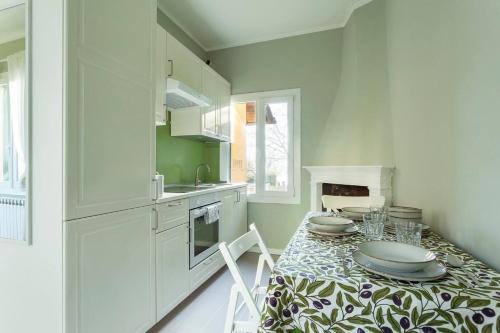 une cuisine avec une table avec des assiettes dessus dans l'établissement Villa Peroni Honeymoon cottage - with swimming pool, à Argegno