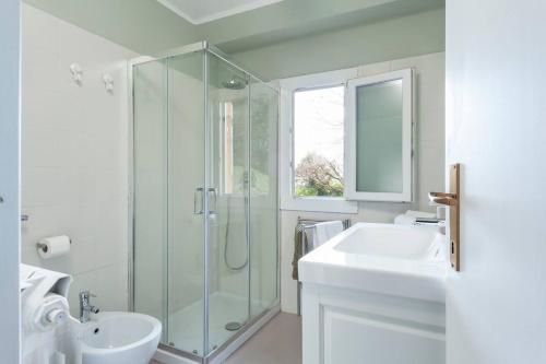 une salle de bain avec une douche en verre et un lavabo dans l'établissement Villa Peroni Honeymoon cottage - with swimming pool, à Argegno