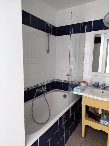 une salle de bain avec une baignoire et un lavabo dans l'établissement A 03 Pool apartment with sea view, à Fouesnant