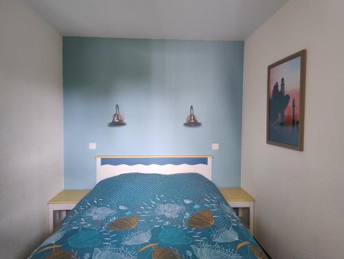 a bedroom with a bed with a blue wall at A 03 Pool apartment with sea view in Fouesnant