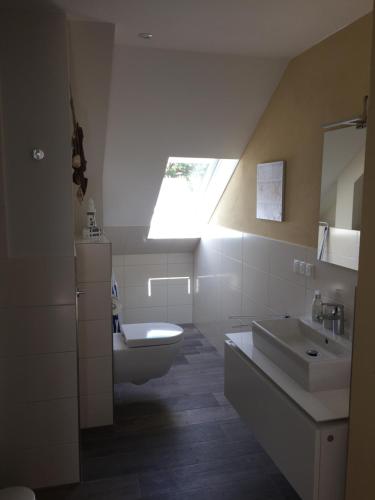 a bathroom with a sink and a toilet and a window at Landhaus am Rebstock Ferienwohnung Möwe in Lancken-Granitz