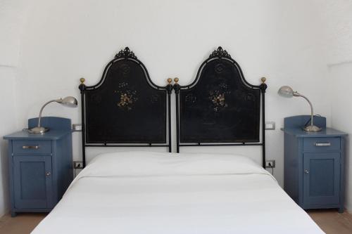 a bedroom with a bed with two blue night stands at Masseria Palombara Grande in Ostuni