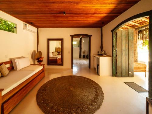 a living room with a bed and a large rug at Pousada Casa da Praia in Caraíva