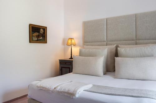 a bedroom with a bed with white pillows and a lamp at Santavenere Hotel in Maratea