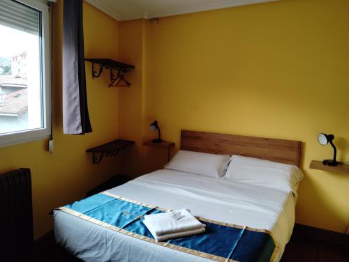 a bedroom with a bed in a room with a window at Txoko Maitea Pentsioa in Urnieta