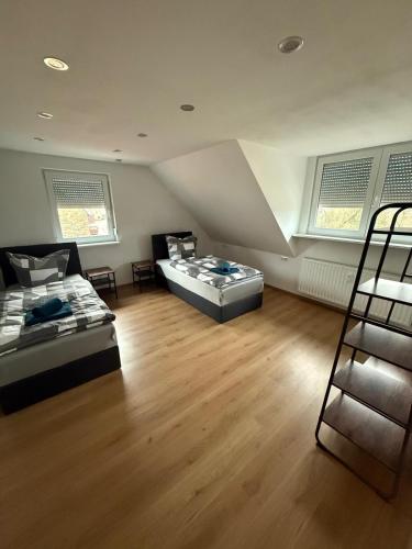 a large room with two beds and a couch at KRAICHGAU # 3-ZKB mit 100qm voll ausgestattet im DG, Monteurzimmer, Self-Check-in in Ittlingen