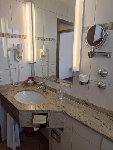 a bathroom with a sink and a mirror at Stadthotel Augsburg in Augsburg