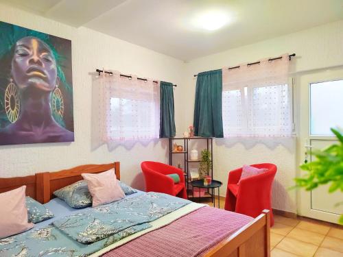 a bedroom with a bed and two red chairs at Apartman Jezz II, Zagreb in Zagreb