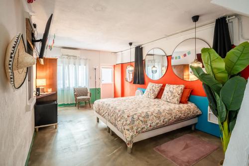 een slaapkamer met een bed met een oranje muur bij Casa Amor Balnéo Sauna in Lézignan-Corbières