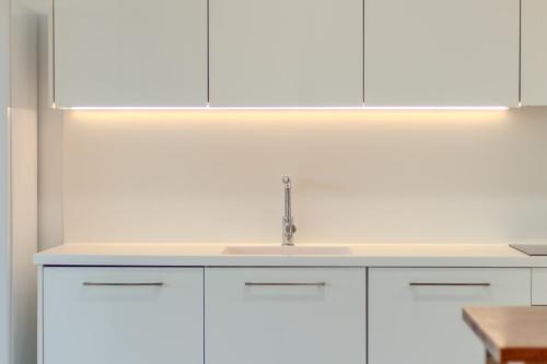 eine Küche mit weißen Schränken und einer Spüle in der Unterkunft The Luxury Village by Domidai in Santa Pola