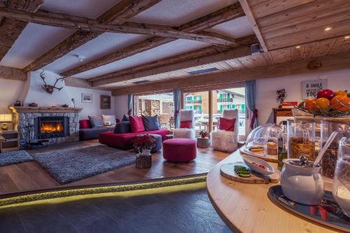 a living room with a red couch and a fireplace at Hotel Mirabeau in Verbier