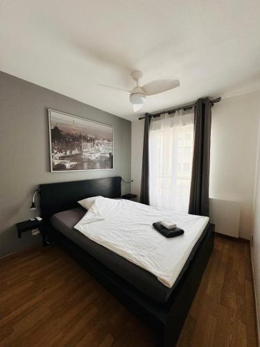 une chambre avec un lit avec une tête de lit noire et une fenêtre dans l'établissement Beautiful Apartment near Geneva, à Saint-Julien-en-Genevois