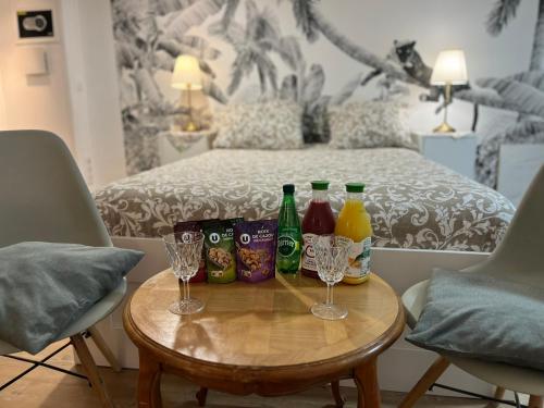 - une table avec des bouteilles, des verres et un lit dans l'établissement Dupleix tout équipé et jardin privé - Long séjour Meudon-Paris, à Meudon