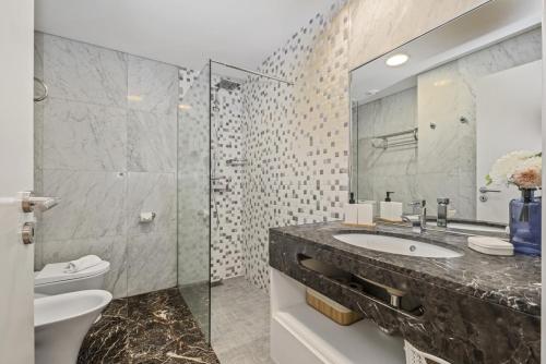 a bathroom with a sink and a toilet and a mirror at Forum Ocean View 5B by Homie in Ilhéu do Gorgulho