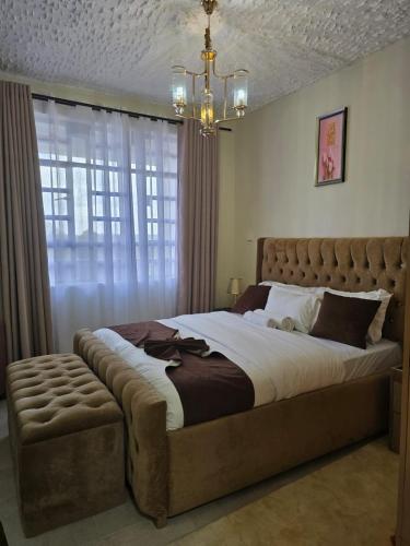 a bedroom with a large bed and a chandelier at Silvia Homes Nanyuki in Nanyuki
