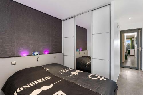 une chambre avec un lit et un grand miroir dans l'établissement Studio Caresse - Port Nature 620 - Luxe - 2 personnes, au Cap d'Agde