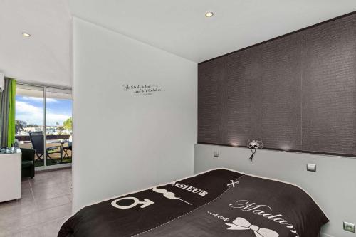 une chambre avec un lit avec un panneau sur le mur dans l'établissement Studio Caresse - Port Nature 620 - Luxe - 2 personnes, au Cap d'Agde
