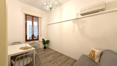 a living room with a table and a chandelier at A42 - Ancona, bilocale in pieno centro in Ancona