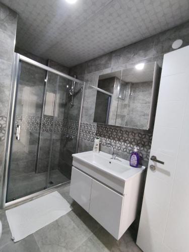 a bathroom with a white sink and a shower at İlkay Suit in Nevsehir