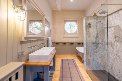 a bathroom with a sink and a shower at Belchamp Hall Hayloft and Stables in Belchamp Otten