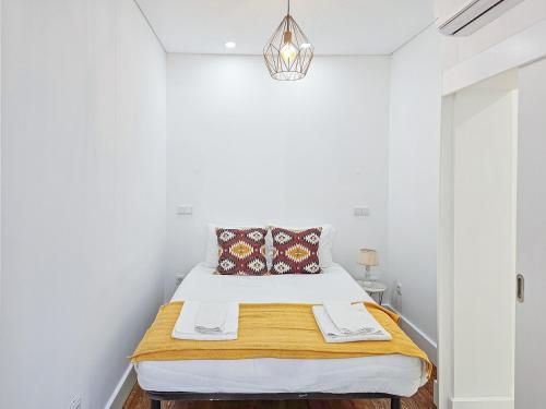 una camera da letto con un letto e pareti bianche di Like a typical Portuguese house with private patio a Lisbona