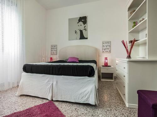 a white bedroom with a bed and a white dresser at Casa Zirocco in Sperlonga