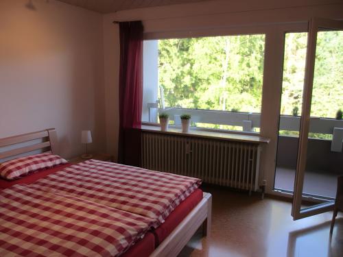 a bedroom with a bed and a large window at Ferienwohnung Brasil, 76 Qm in Schonach