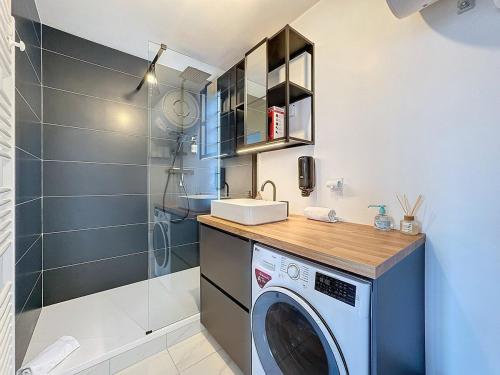 une machine à laver dans une salle de bain avec douche dans l'établissement Appartement Clermont-Ferrand -Besset, à Clermont-Ferrand